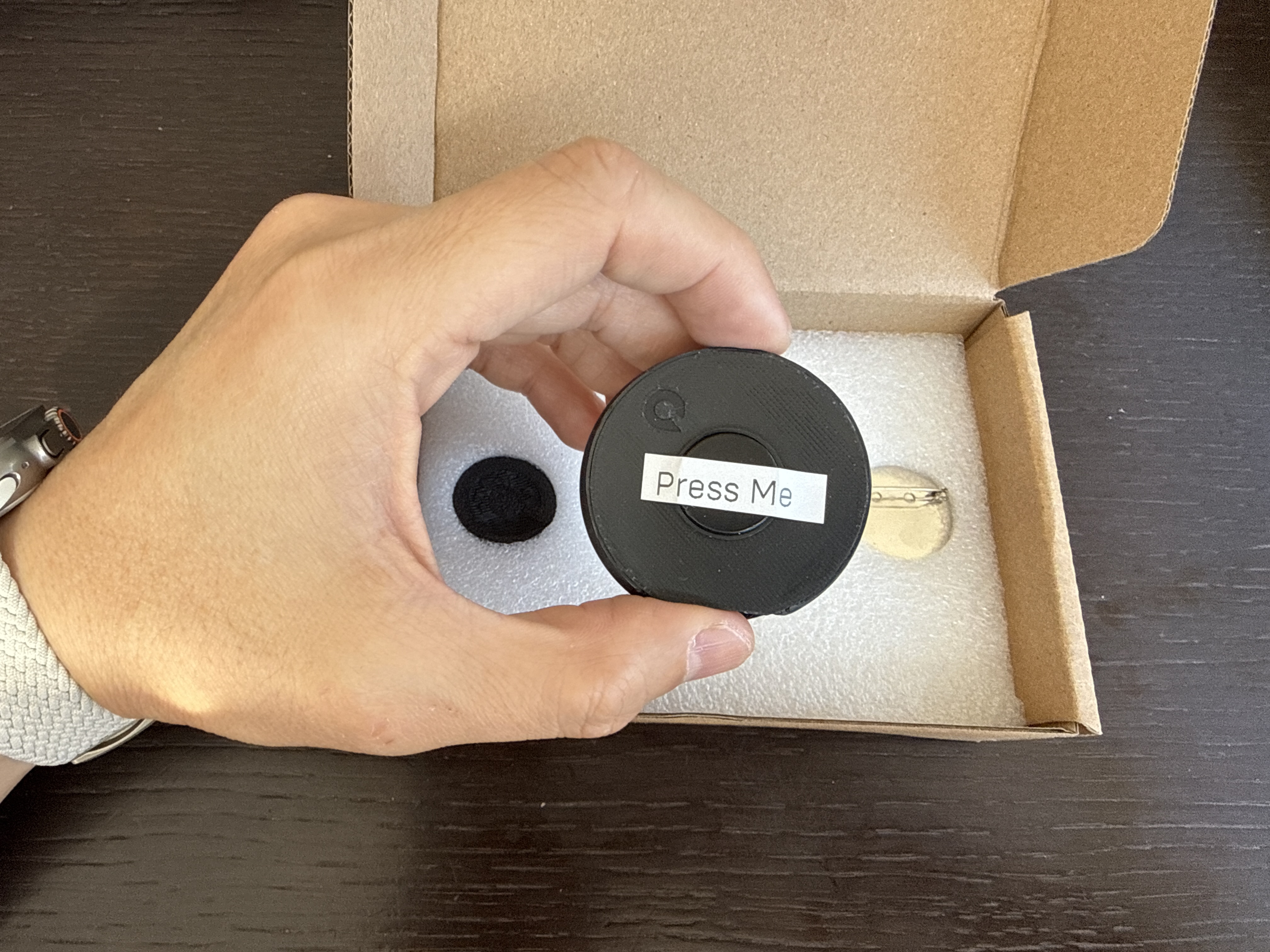 Pressing the magnetic button on the back of the QPIN case to wake it from Deep Sleep mode